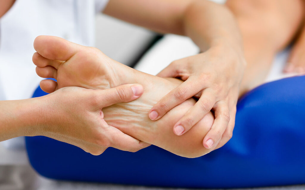 Profissional avaliando dor e possíveis fraturas causadas pela osteoporose nos pés - site Dr. Marcelo Corrêa - Reumatologista em Belém - PA
